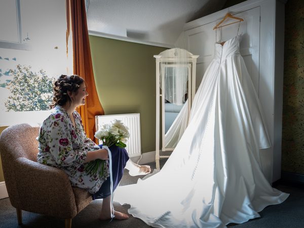 Adam and Abbey’s wedding at Tottington Manor – bride getting ready beside her wedding dress