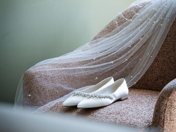 Adam and Abbey’s wedding at Tottington Manor – veil and shoes on an armchair
