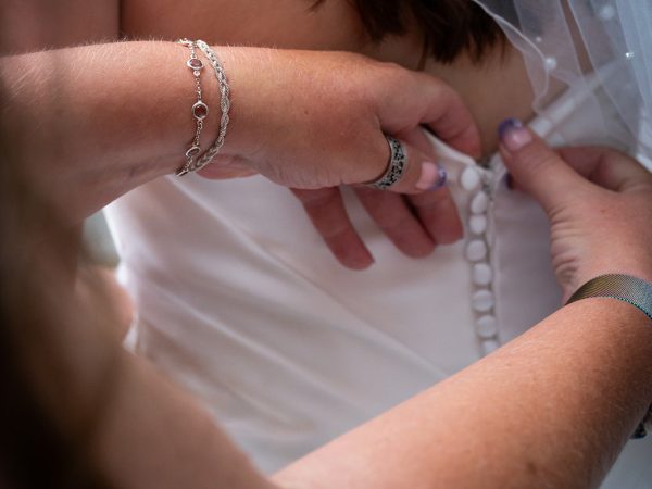 Adam and Abbey’s wedding at Tottington Manor – buttoning up the wedding dress