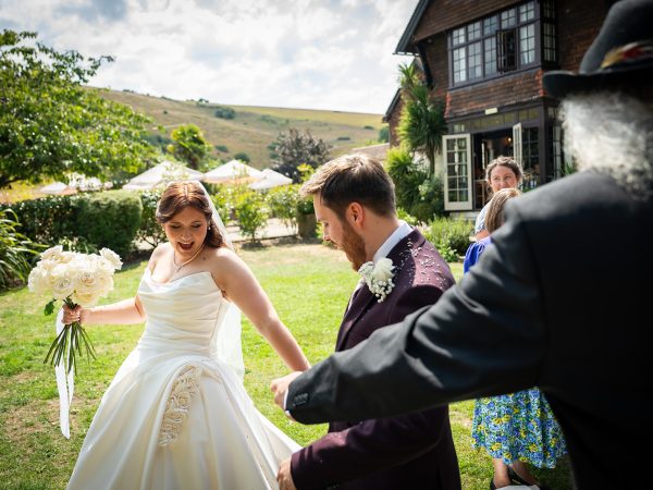 Adam and Abbey’s wedding at Tottington Manor – bride and guests on the lawn with the Downs behind