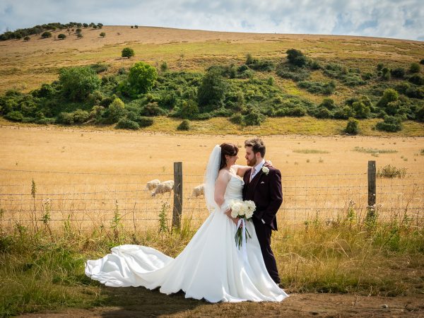 Adam and Abbey’s wedding at Tottington Manor – couple portrait in a South Downs field