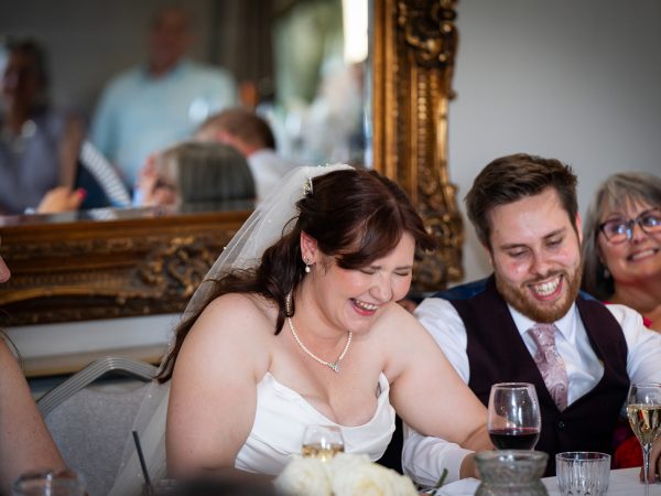 Adam and Abbey’s wedding at Tottington Manor – couple laughing at the top table
