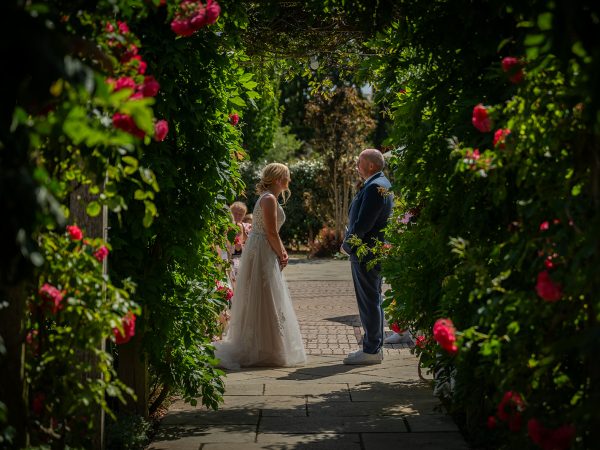 Holly and Andy’s wedding at Field Place – ceremony beneath the rose arch
