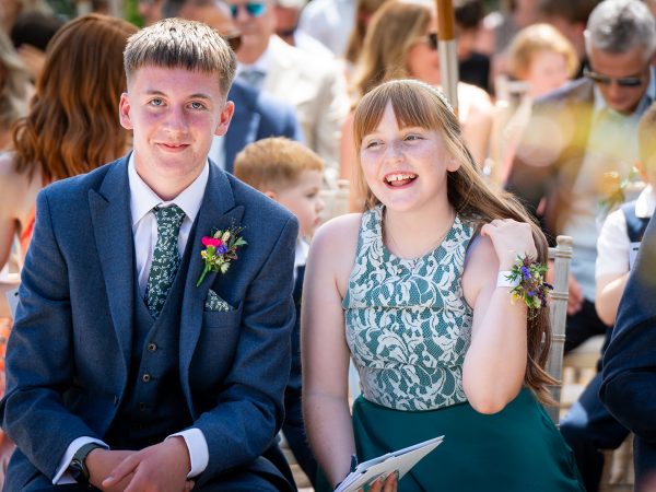 Holly and Andy’s wedding at Field Place – young guests smiling at the ceremony