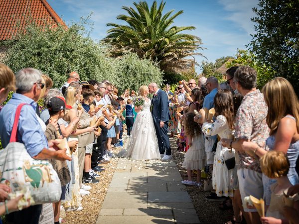Holly and Andy’s wedding at Field Place – the confetti line by the palm trees