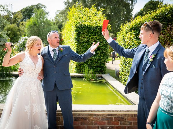 Holly and Andy’s wedding at Field Place – bride, groom and friends by the lily pond