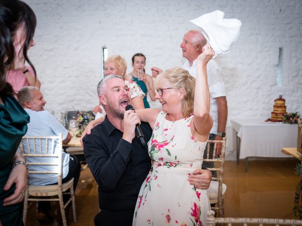 Holly and Andy’s wedding at Field Place – singing waiter with a guest