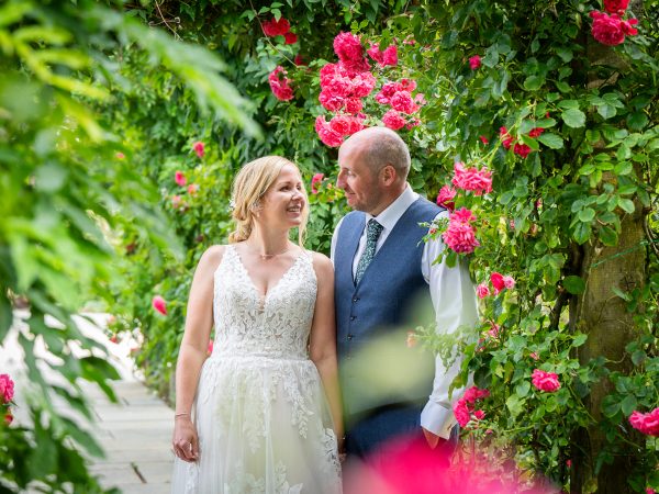 Holly and Andy’s wedding at Field Place – bride and groom among the roses