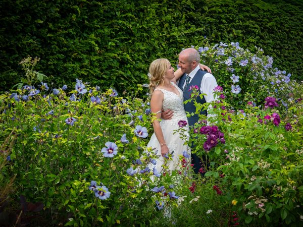 Holly and Andy’s wedding at Field Place – bride and groom among the summer flowers