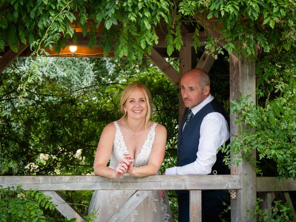 Holly and Andy’s wedding at Field Place – bride and groom under the pergola
