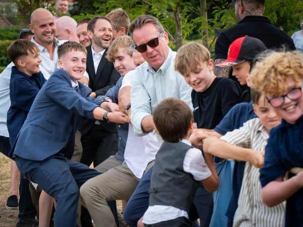 Holly and Andy’s wedding at Field Place – tug of war on the lawn
